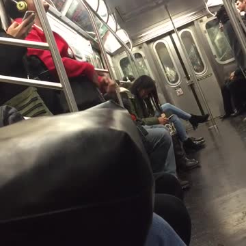 Guy red sweater yellow headphones singing on subway