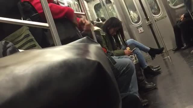 Guy red sweater yellow headphones singing on subway