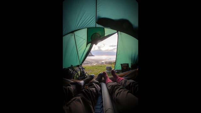 Daytime view from inside of your tent next to running water and birds chirping