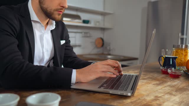 Man in a suit works from the kitchen