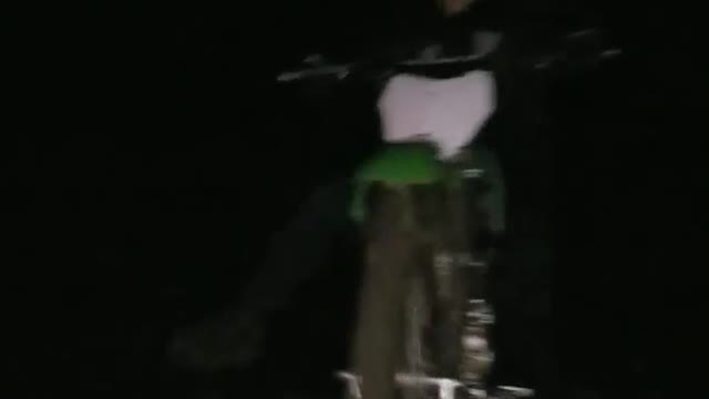 Guy rides green dirt bike up ramp onto red truck and plows runs into camera guy