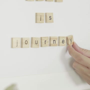A Person Holding Scrabble Tiles
