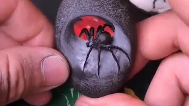 Carving a river stone into a Black Widow