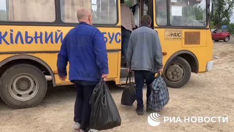 Nakládání uprchlíků z Azotu do autobusů Lidových milicí LLR. Autobus jede k ruským hranicím