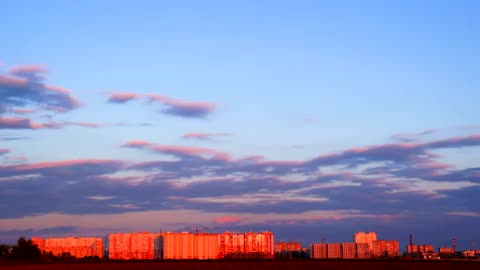 Clouds traveling over a city at dusk