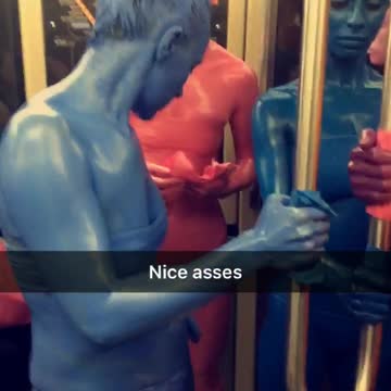 Women painted in different colors stand by one another