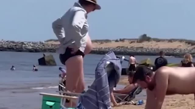 THIS MAN DIGS SAND TO FIT ON HIS LOVELY WIFE'S PREGGY BELLY