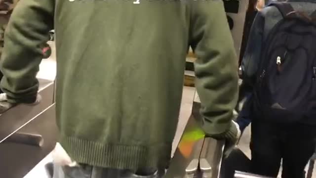 Guy green jacket doing push ups between turnstile