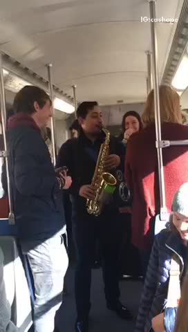 Guy playing saxophone on subway train
