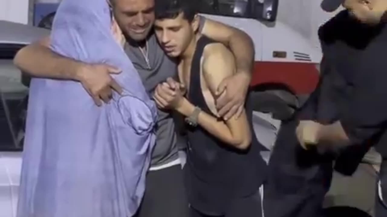 Palestinian teenagers weep alongside their father