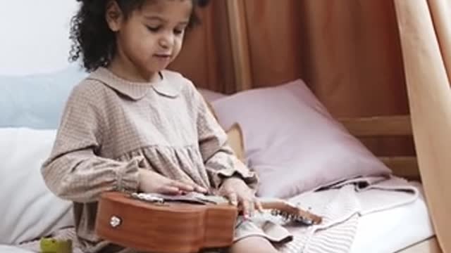 A Girl Learning To Play A Ukelele