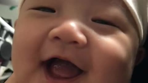 A baby who laughs when he touches his chin.