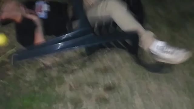 Guy standing on top of black chair and breaking it