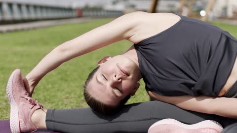 A Woman With Good Flexibility Stretching Outdoors On Grassy Lawn