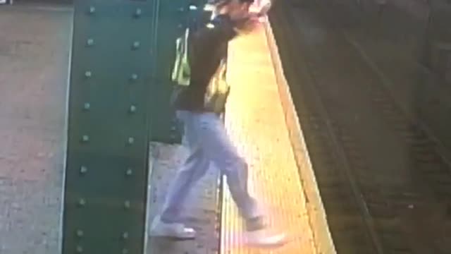 Man in brown vest dancing in subway platform