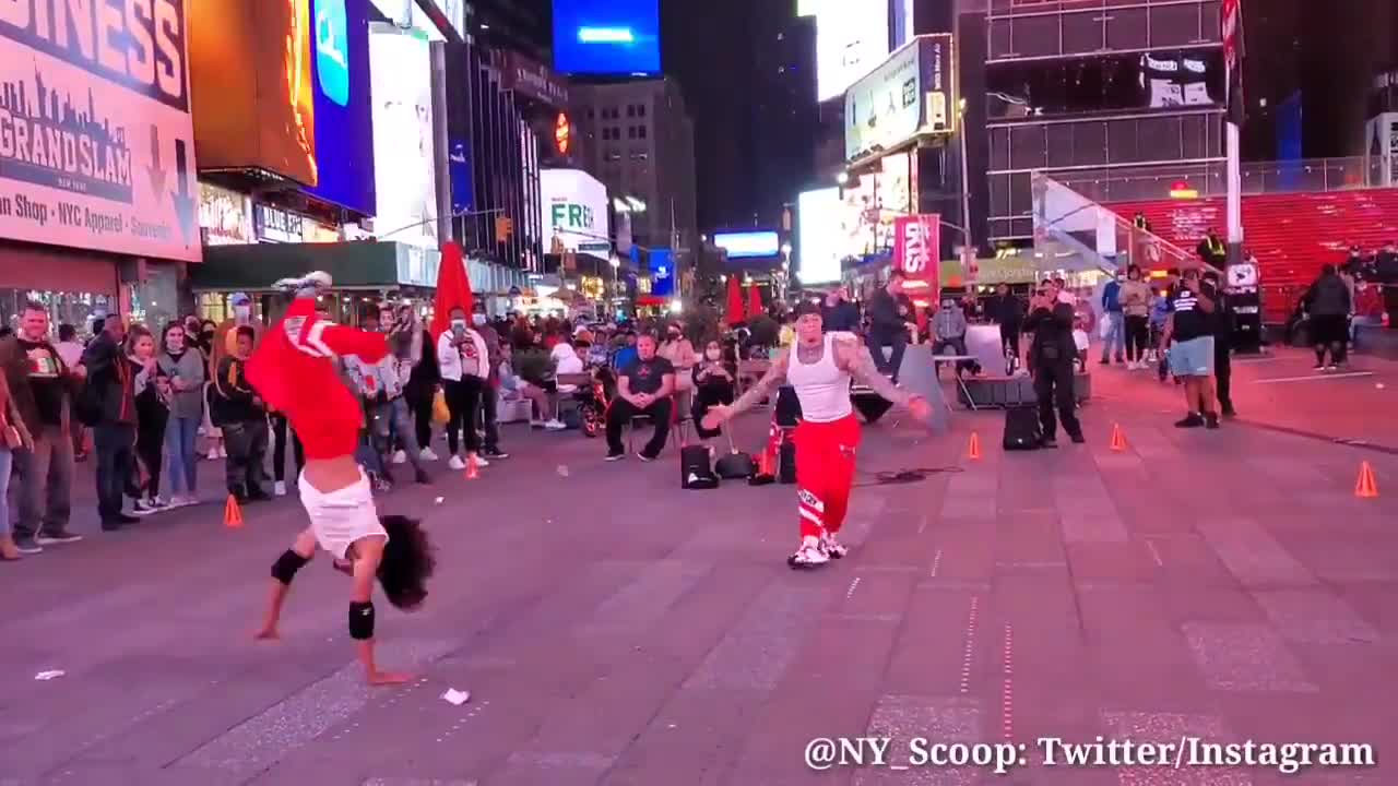 Two acrobats take the streets of Times Square NYC to show their tricks.