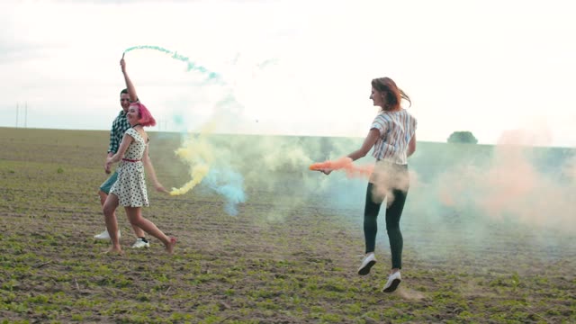 Friends with colored smoke bombs