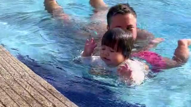 My dad teaches me to swim.