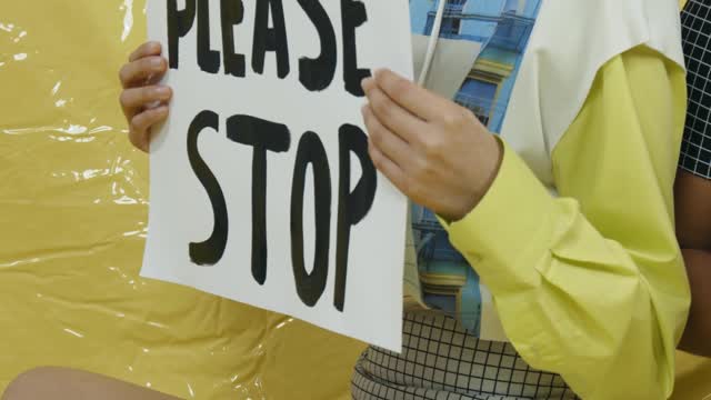 Women on the Sitting on the Floor Holding Signs