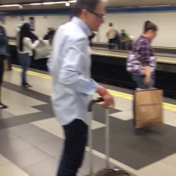 Man in all blue paint waits for subway