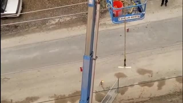 A crane is burning, with a man in it