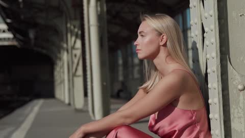 woman-in-a-pink-dress-modeling-in-a-train-station