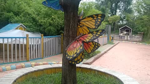 Butterflies flitted from flower to tree.