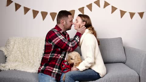 a couple in love is tender and kisses with a dog in her arms