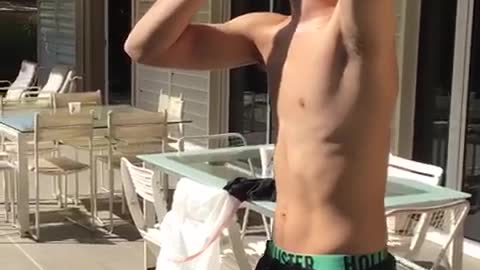 Shirtless teen cracks beer on wall and chugs it