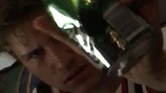 Guy hitting beer with tool and spilling it on himself