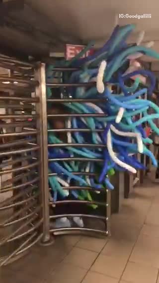 Body suit of blue balloons in subway station