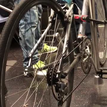 Silver bike locked to subway train pole