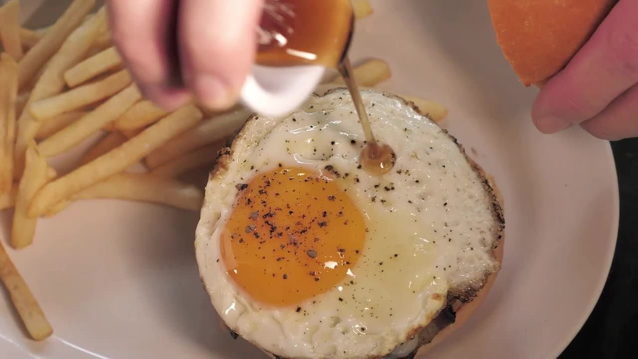 Burger being prepared with french fries