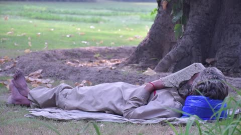 SHORT FOOTAGE OF POOR HOMELESS MAN SPLEEPING IN PARK.