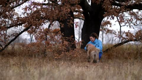 Smiling woman calling her dog in the rain