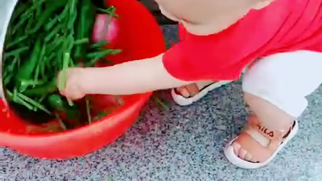 The son helps his mother wash vegetables to prepare for lunch!