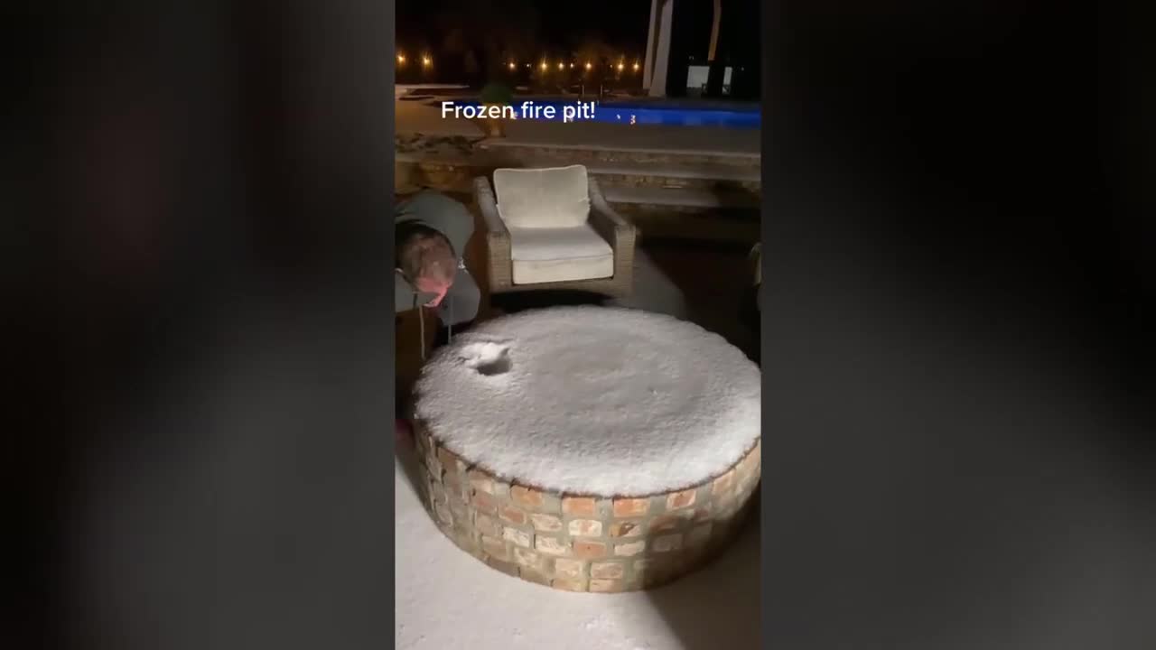 Guy Lights Frozen Fire Pit At the Back Porch Of His House