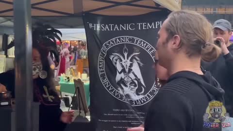 Ο κόσμος στέκεται σειρά να "ευλογηθει" με ανάποδο σταυρό από την εκκλησία του Σατανά.