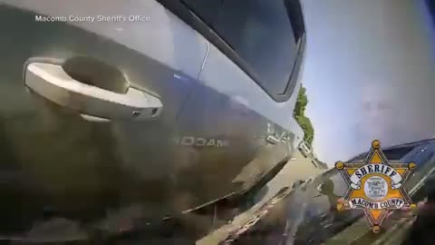 Video shows sheriff's deputy climb out of moving patrol vehicle to help driver in Michigan