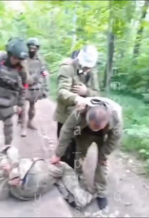 Russian soldiers hit, kick and fire next to the head of Ukrainian POW