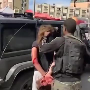 Palestinian militants taking an Israeli woman hostage, hours after Hamas launched