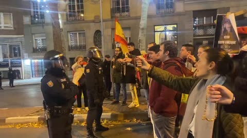 Spanish Catholics hold up their Rosaries to police after a heavy handed crackdown on their prayer