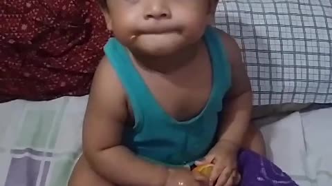 Cute baby try eating orange