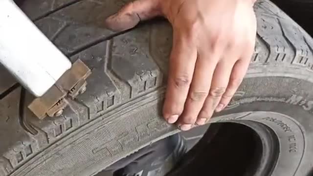 The tire of the car is seriously worn, and the tread is cut again to repair the car.