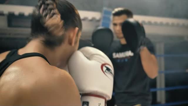Woman doing kickbox movements with a coach