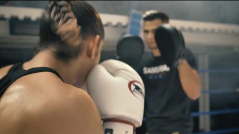 Woman doing kickbox movements with a coach