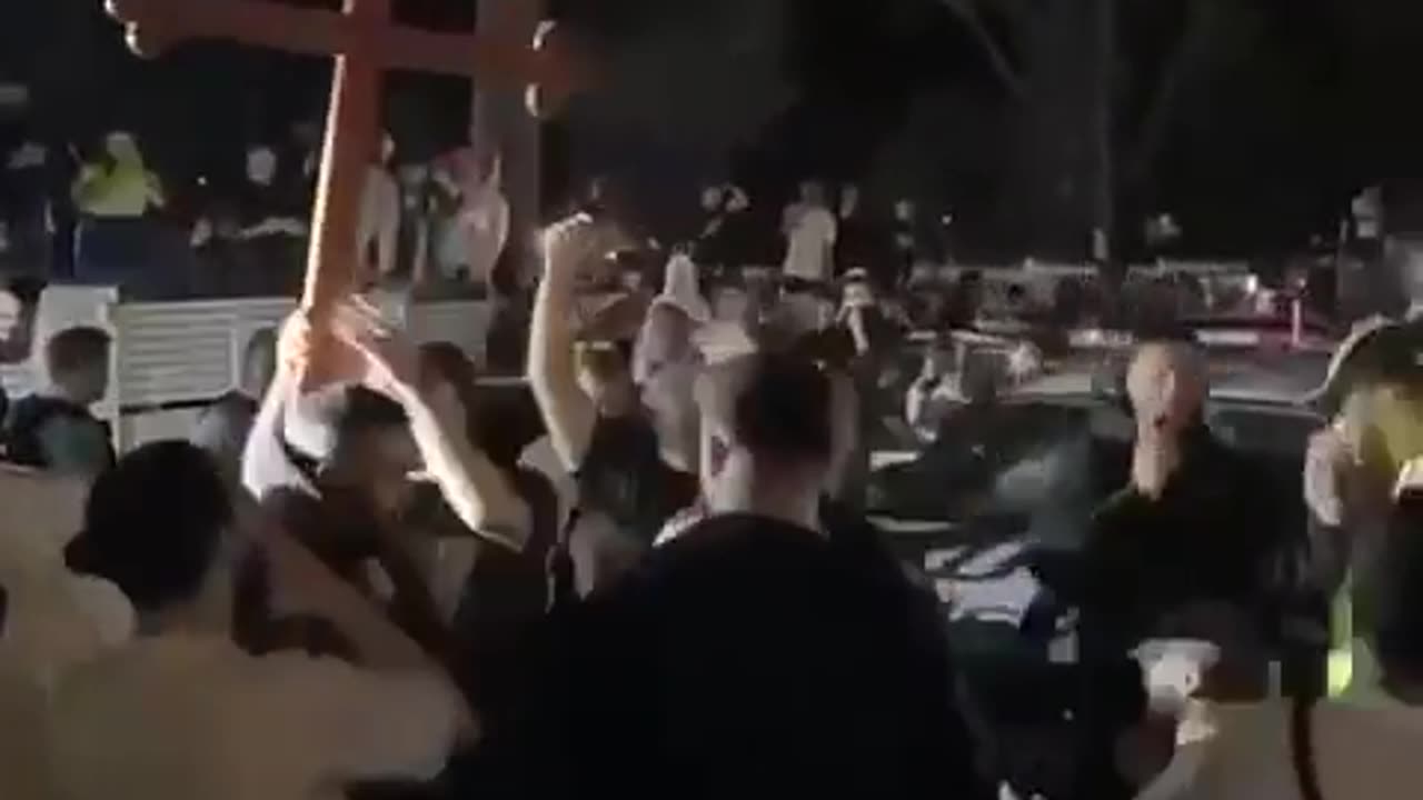 Christians in Australia hold up a cross outside the jail where a terrorist is being