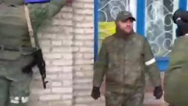 Soldiers of the DPR army raise the flag over the administration of the Left Bank district of Mariupol