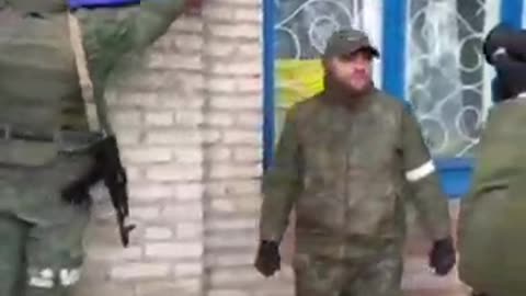 Soldiers of the DPR army raise the flag over the administration of the Left Bank district of Mariupol