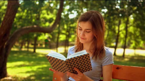Girl reading a book in nature